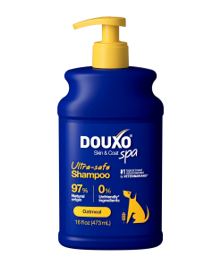 The front of a 16 fl oz bottle of DOUXO Oatmeal Shampoo for dogs, featuring a dark blue bottle with a yellow pump dispenser and yellow label accents.